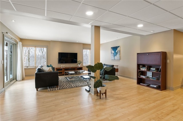 living room featuring a paneled ceiling and light wood-type flooring