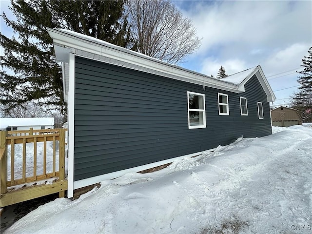 view of snow covered exterior featuring a wooden deck