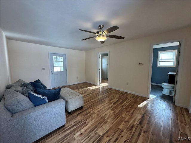 living room with dark hardwood / wood-style floors, a wealth of natural light, and ceiling fan