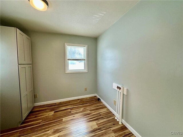 clothes washing area with cabinets, hookup for a washing machine, and hardwood / wood-style floors