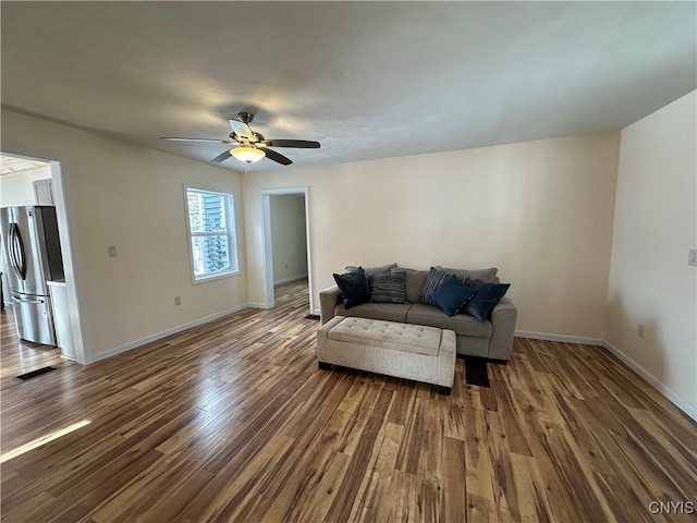 living room featuring dark wood-type flooring and ceiling fan