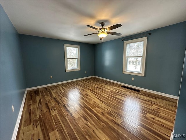 empty room with hardwood / wood-style flooring and ceiling fan