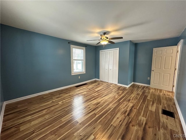 unfurnished bedroom featuring ceiling fan, wood-type flooring, and a closet