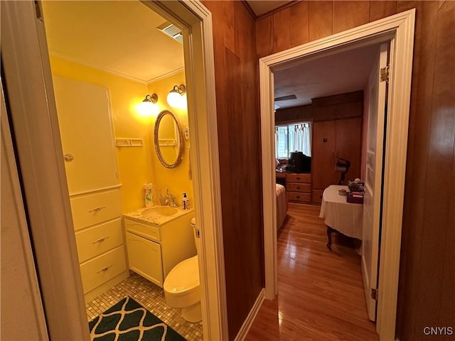 bathroom featuring ornamental molding, vanity, toilet, and hardwood / wood-style floors