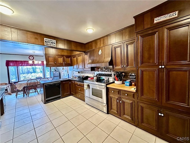 kitchen featuring light tile patterned flooring, stainless steel range with electric stovetop, a chandelier, dishwasher, and wall chimney range hood