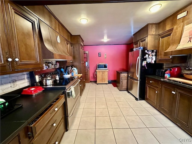 kitchen with backsplash, stainless steel appliances, and light tile patterned flooring