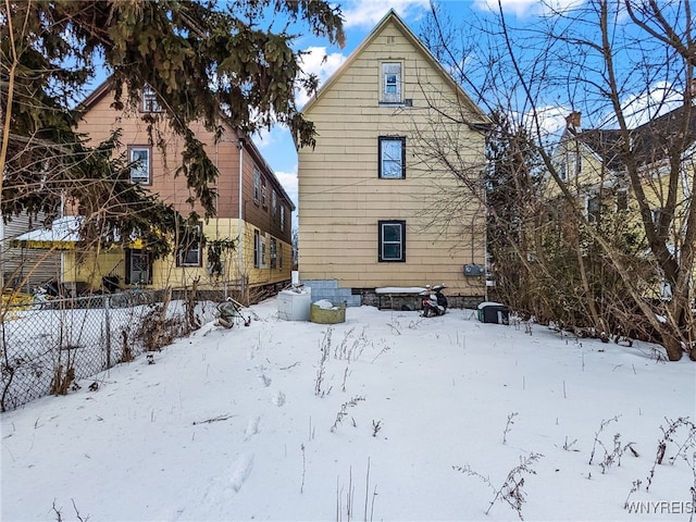 view of snow covered back of property