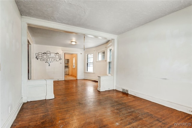 spare room with dark hardwood / wood-style flooring and a textured ceiling