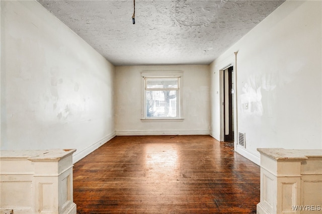 unfurnished room with dark hardwood / wood-style floors and a textured ceiling