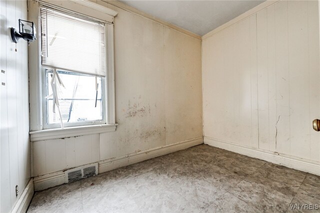 spare room featuring wood walls