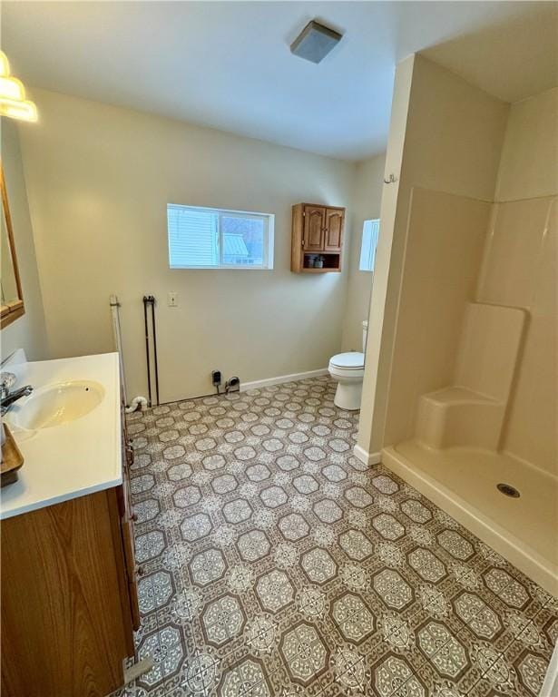 bathroom featuring vanity, a shower, and toilet