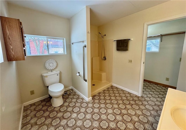 bathroom with a shower, vanity, and toilet