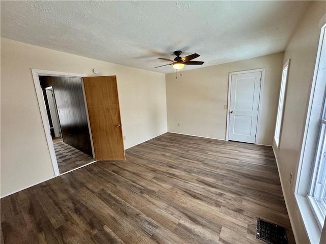 unfurnished room with ceiling fan, wood-type flooring, and a textured ceiling