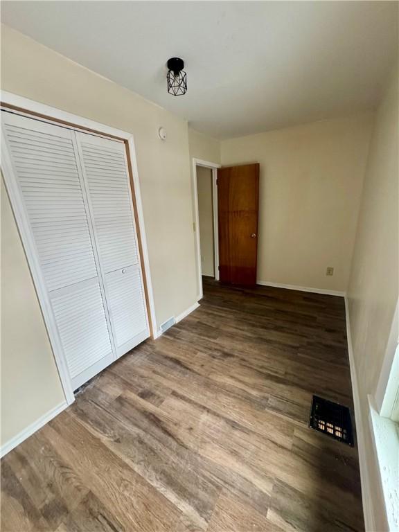 unfurnished bedroom with wood-type flooring and a closet