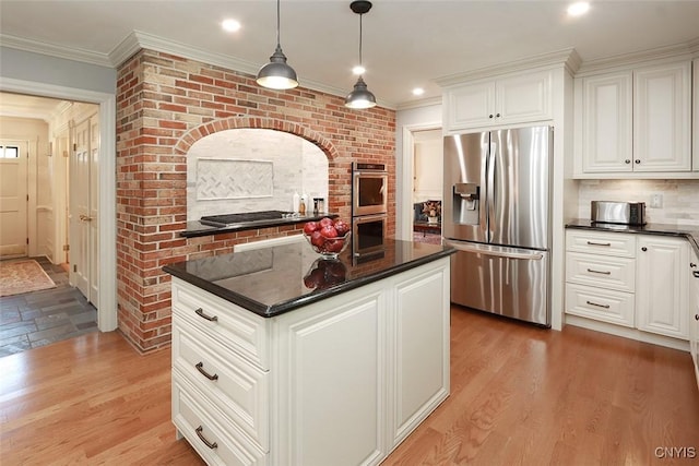 kitchen featuring hanging light fixtures, white cabinetry, appliances with stainless steel finishes, and light hardwood / wood-style floors