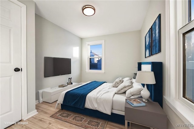 bedroom featuring vaulted ceiling and light hardwood / wood-style floors