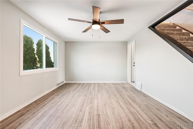 empty room with ceiling fan and light hardwood / wood-style flooring