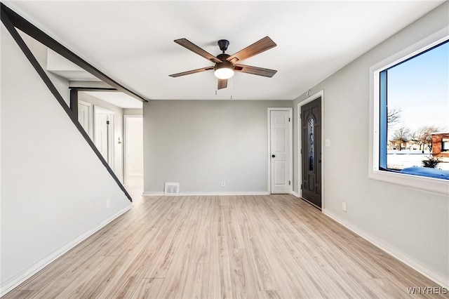 empty room with ceiling fan and light hardwood / wood-style floors