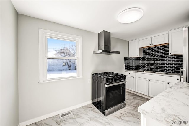 kitchen with sink, black gas range, white cabinetry, backsplash, and wall chimney exhaust hood