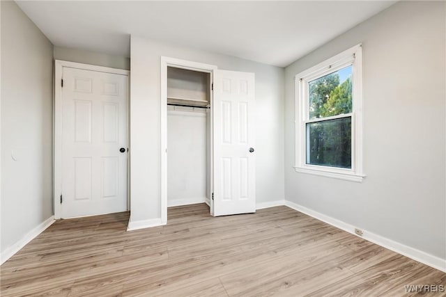 unfurnished bedroom featuring a closet and light wood-type flooring