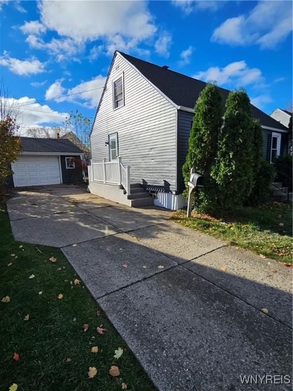 view of property exterior with a garage and an outdoor structure