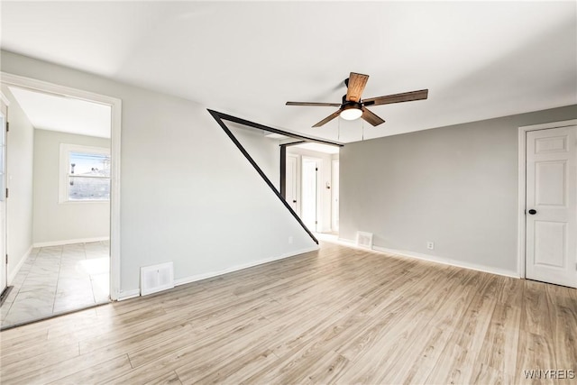 empty room with ceiling fan and light hardwood / wood-style floors