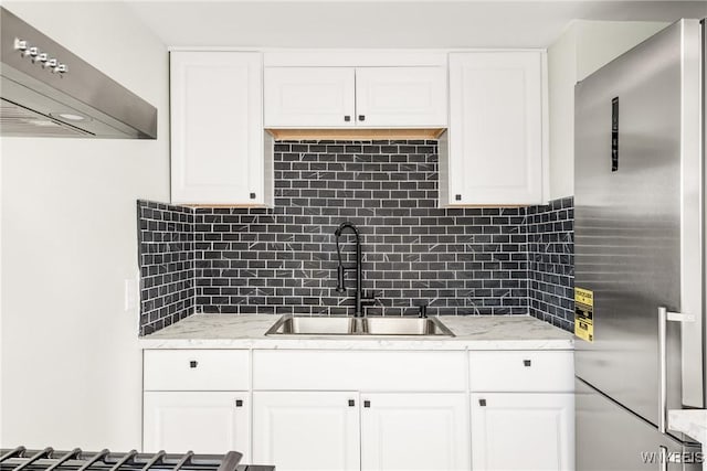 kitchen with extractor fan, sink, high end refrigerator, and white cabinets