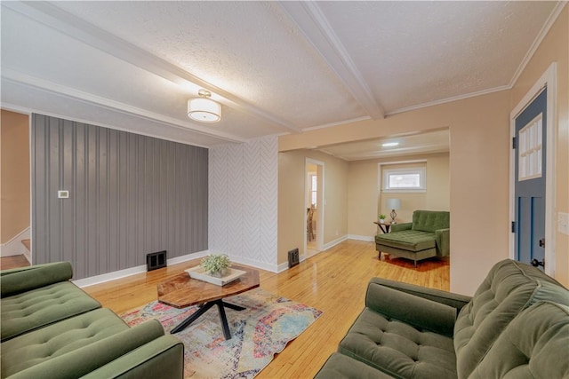 living room featuring beamed ceiling, wood-type flooring, and crown molding