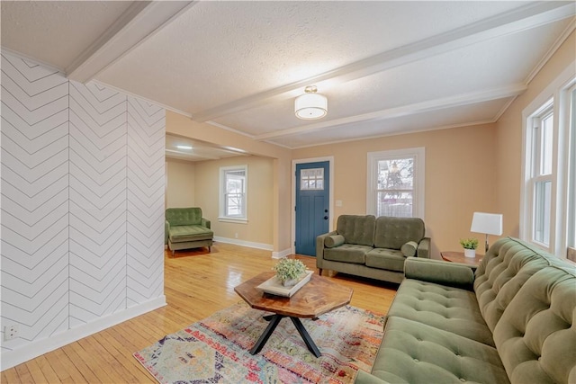 living room with crown molding, light hardwood / wood-style flooring, and beamed ceiling