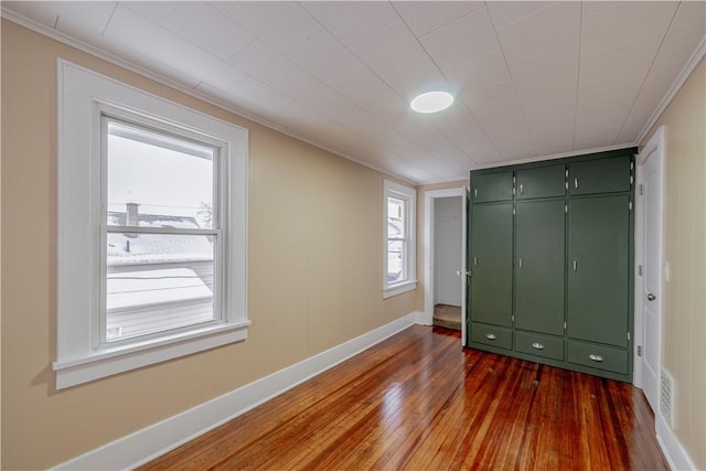 unfurnished bedroom with ornamental molding and dark hardwood / wood-style flooring