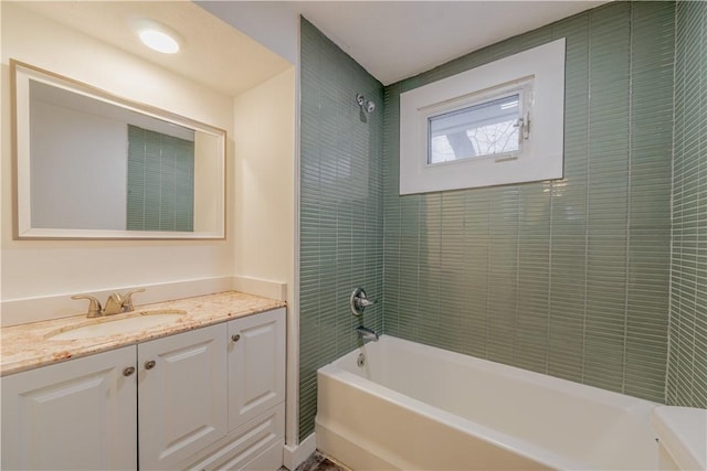 bathroom featuring tiled shower / bath and vanity