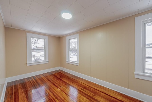 empty room featuring hardwood / wood-style floors and crown molding