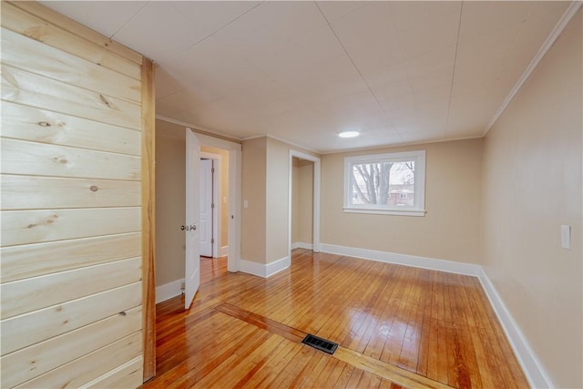 empty room with crown molding and hardwood / wood-style flooring