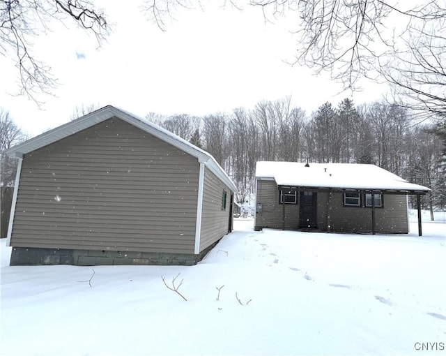 view of snow covered rear of property