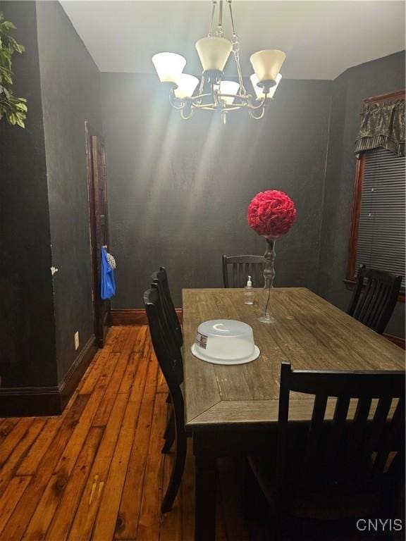 dining area with hardwood / wood-style flooring and a chandelier