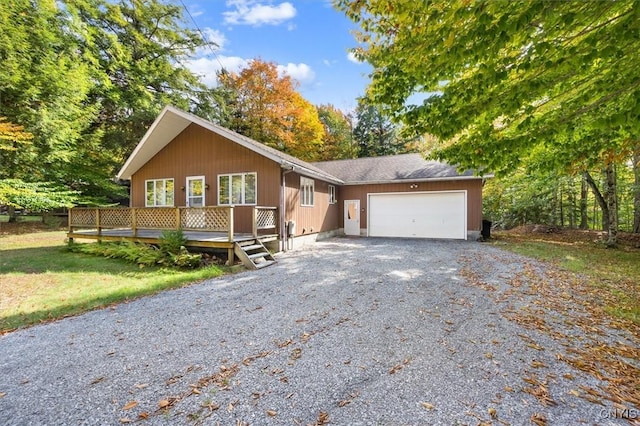 single story home with a garage and a wooden deck