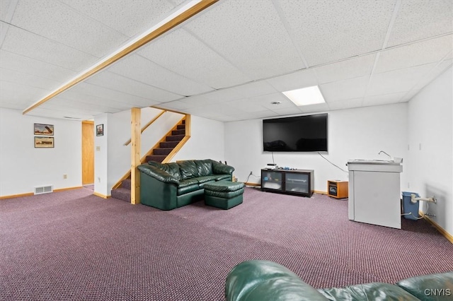 living room featuring carpet and a paneled ceiling