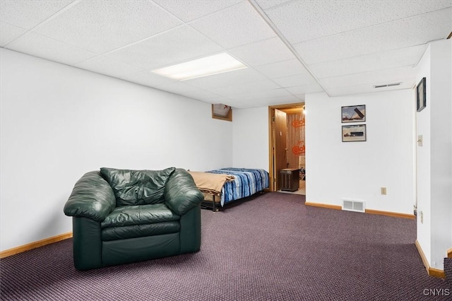 bedroom featuring carpet floors and a drop ceiling