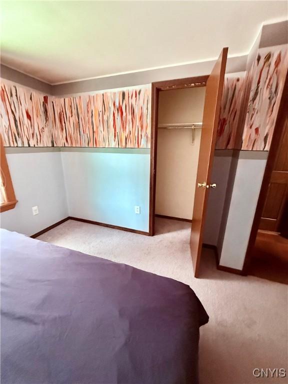 unfurnished bedroom with light carpet and a closet