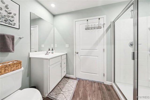 bathroom featuring vanity, wood-type flooring, toilet, and walk in shower