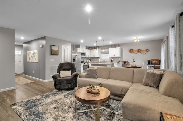 living room with sink and light hardwood / wood-style floors