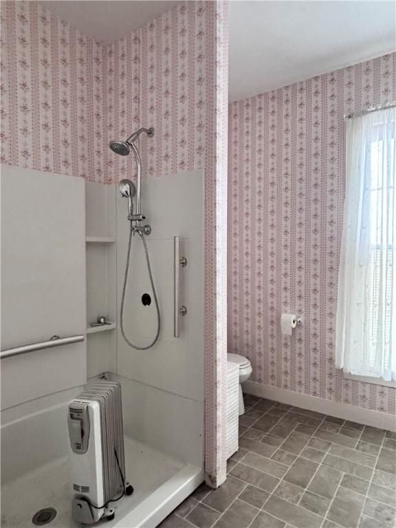 bathroom with walk in shower, radiator heating unit, and toilet