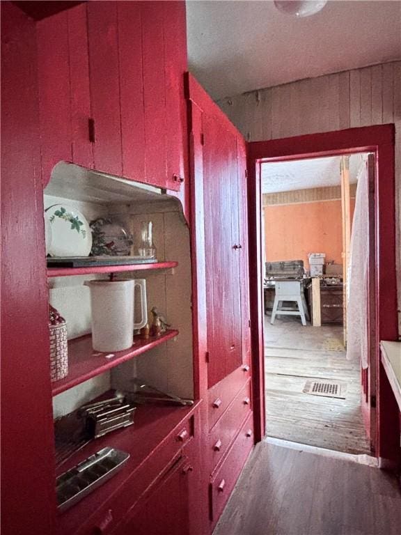 interior space with dark wood-type flooring and wood walls