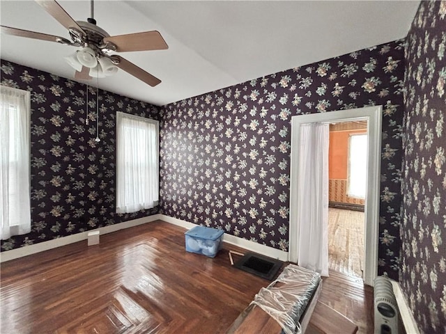 unfurnished room featuring radiator heating unit, a wealth of natural light, parquet flooring, and ceiling fan