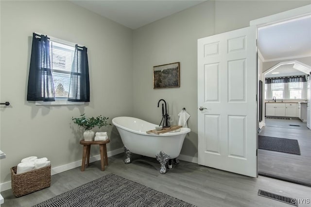 bathroom with sink, hardwood / wood-style floors, and a bathtub