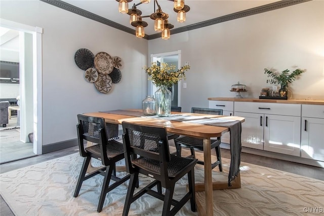 dining space featuring ornamental molding, a chandelier, and light wood-type flooring