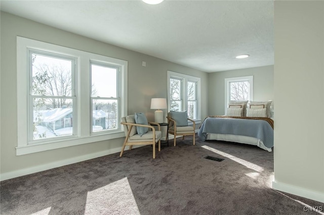 bedroom with dark colored carpet and a textured ceiling