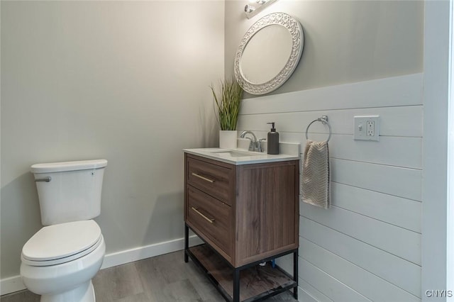 bathroom with hardwood / wood-style flooring, vanity, and toilet