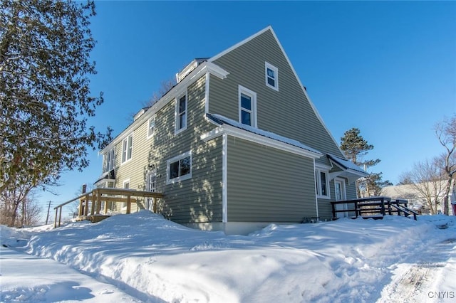 view of snowy exterior featuring a deck