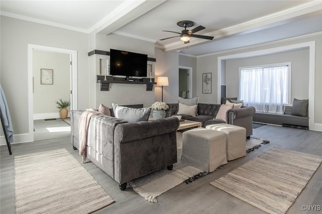 living room featuring a brick fireplace, light hardwood / wood-style flooring, ornamental molding, and ceiling fan